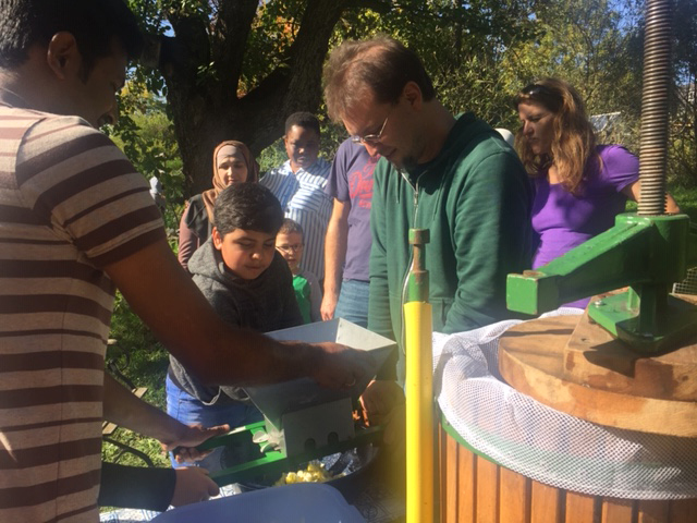 Mitglieder des Interkulturellen Gartens beim Apfelsaftpressen mit den Kindern